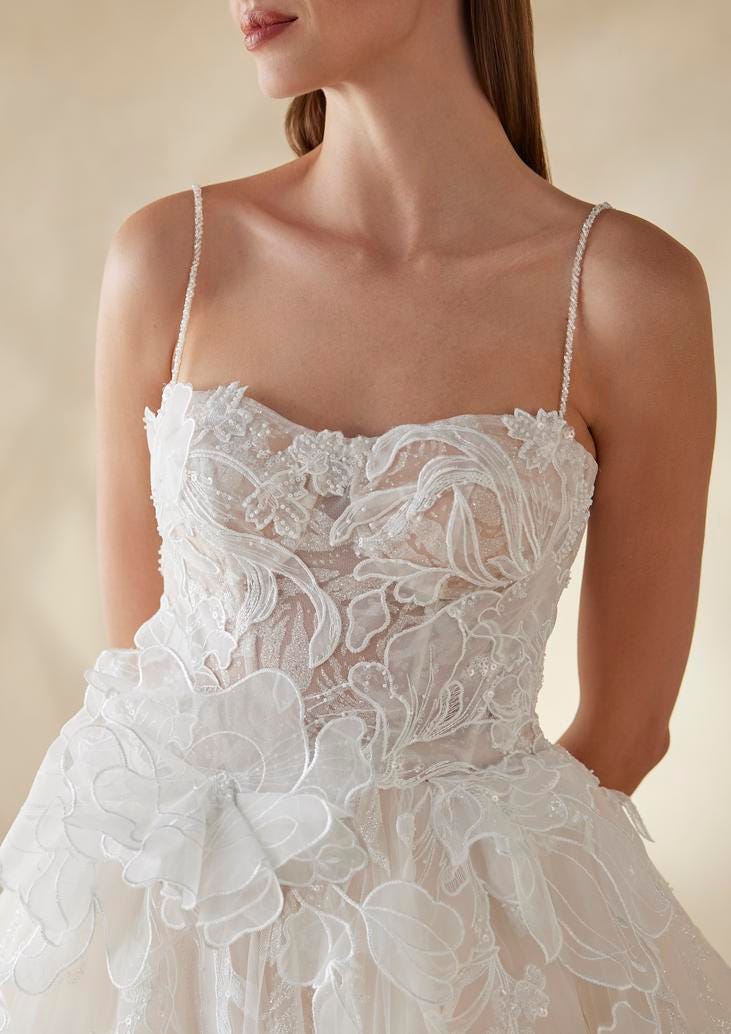 Woman wearing a sweetheart neckline wedding dress with floral appliqués on the bodice