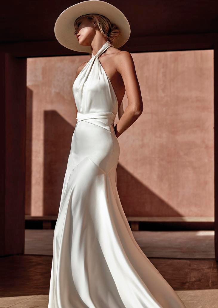 Mujer vestida de novia de perfil con un vestido moderno con un sombrero
