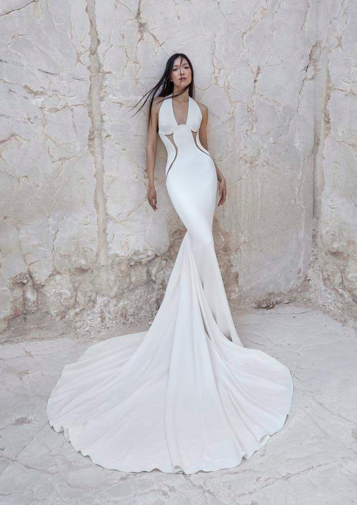 Une belle mariée arbore une robe de mariée sirène sans manches à la coupe moderne et aux découpes travaillées