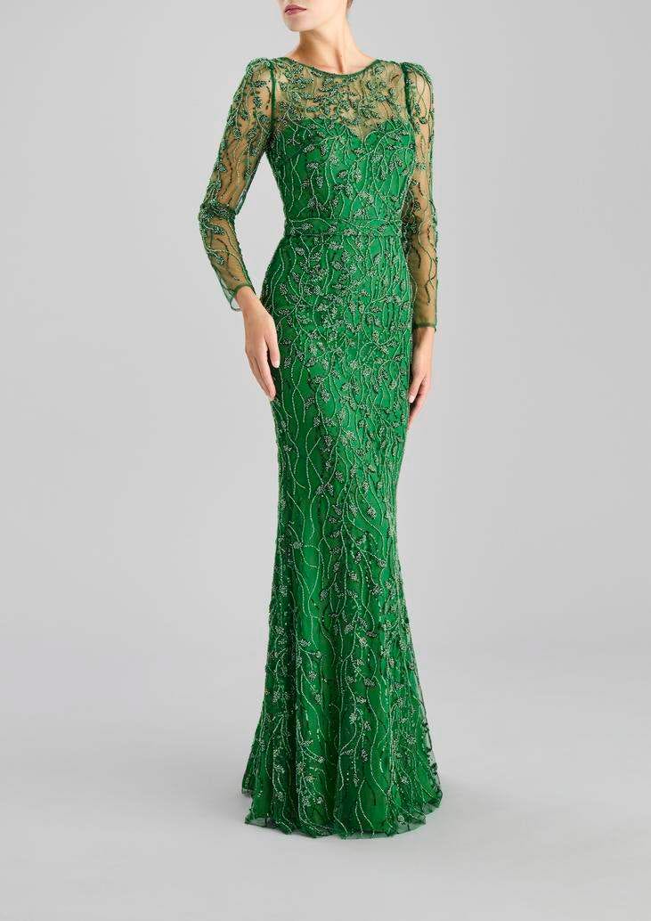 Frau in langem grünen Fit and Flare Kleid mit Spitzenverzierungen und durchsichtigen langen Ärmeln