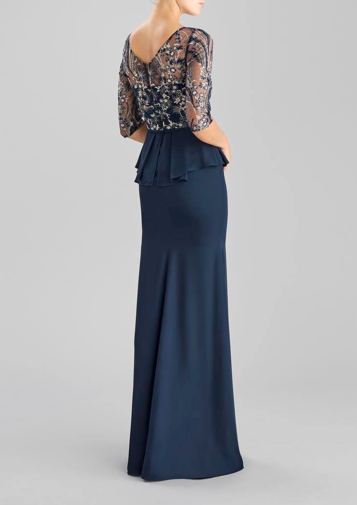 Woman wearing a navy sheath party dress with bateau neckline and three-quarter sleeves